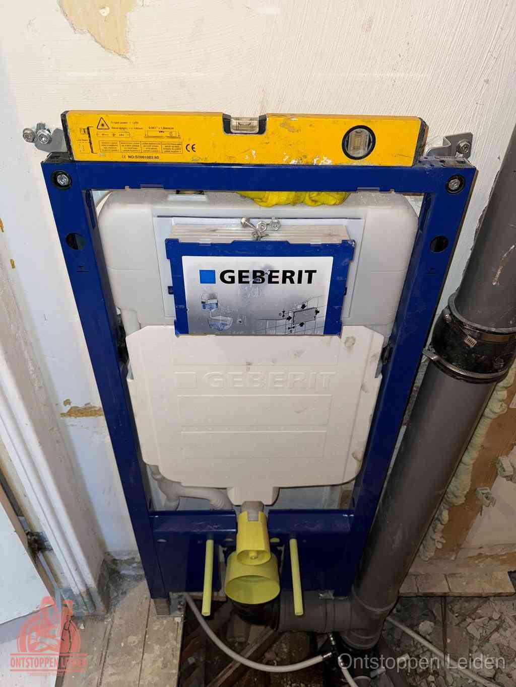 Een Geberit inbouwreservoir met frame voor een hangtoilet tegen de wand, met de afvoerbocht naar de vloer, kenmerkend voor een verstopt hangtoilet in Leiden