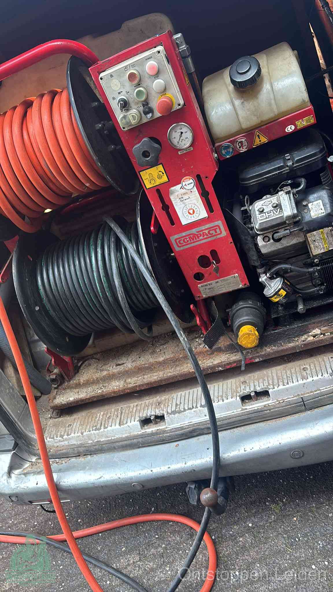 Een rood hogedruk-rioolreinigingstoestel in de laadbak van de bedrijfsbus, apparatuur voor een hardnekkige afvoerverstopping in Leiden
