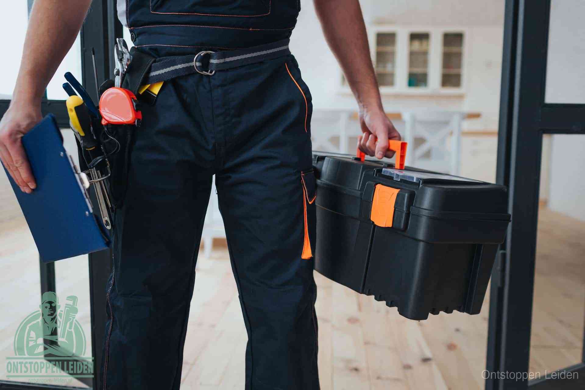 Een monteur met gereedschapsriem en klembord, klaar om een transparante prijs voor het afvoer ontstoppen in Leiden te geven