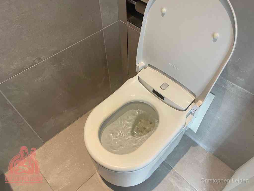 Een toiletpot vol troebel water met drijvend papier en restanten, de meest voorkomende oorzaak van een verstopte wc in Leiden