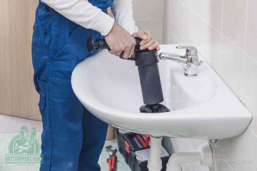 Een te ruwe doe-het-zelf poging met een hand-pomp op de afvoer van een badkamer-wastafel, een van de veelgemaakte fouten bij afvoer ontstoppen in Leiden