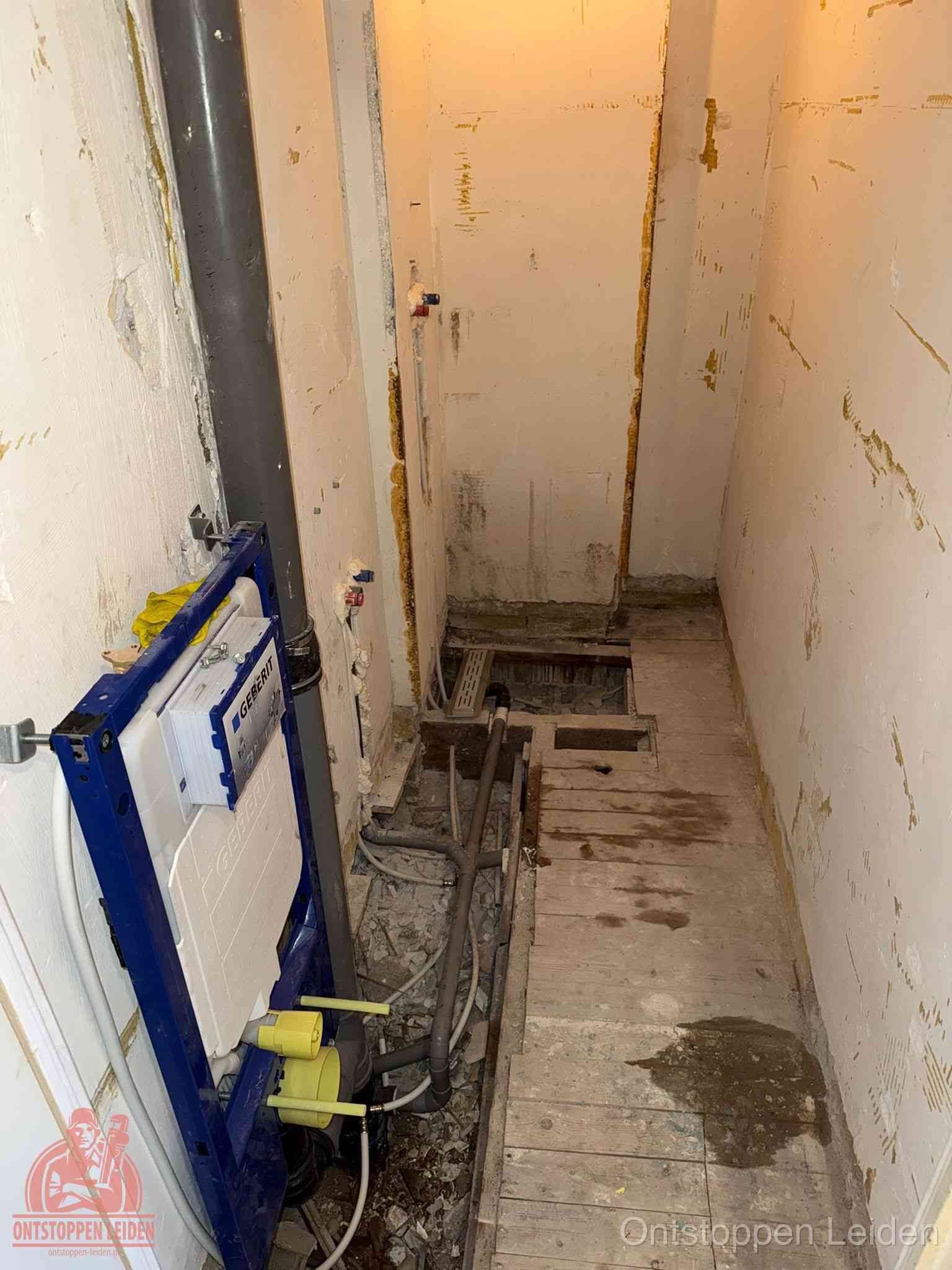 Een opgebroken toiletruimte tijdens renovatie met een Geberit inbouwreservoir en blootliggende oude afvoerleidingen, typisch voor oudere woningen in Leiden